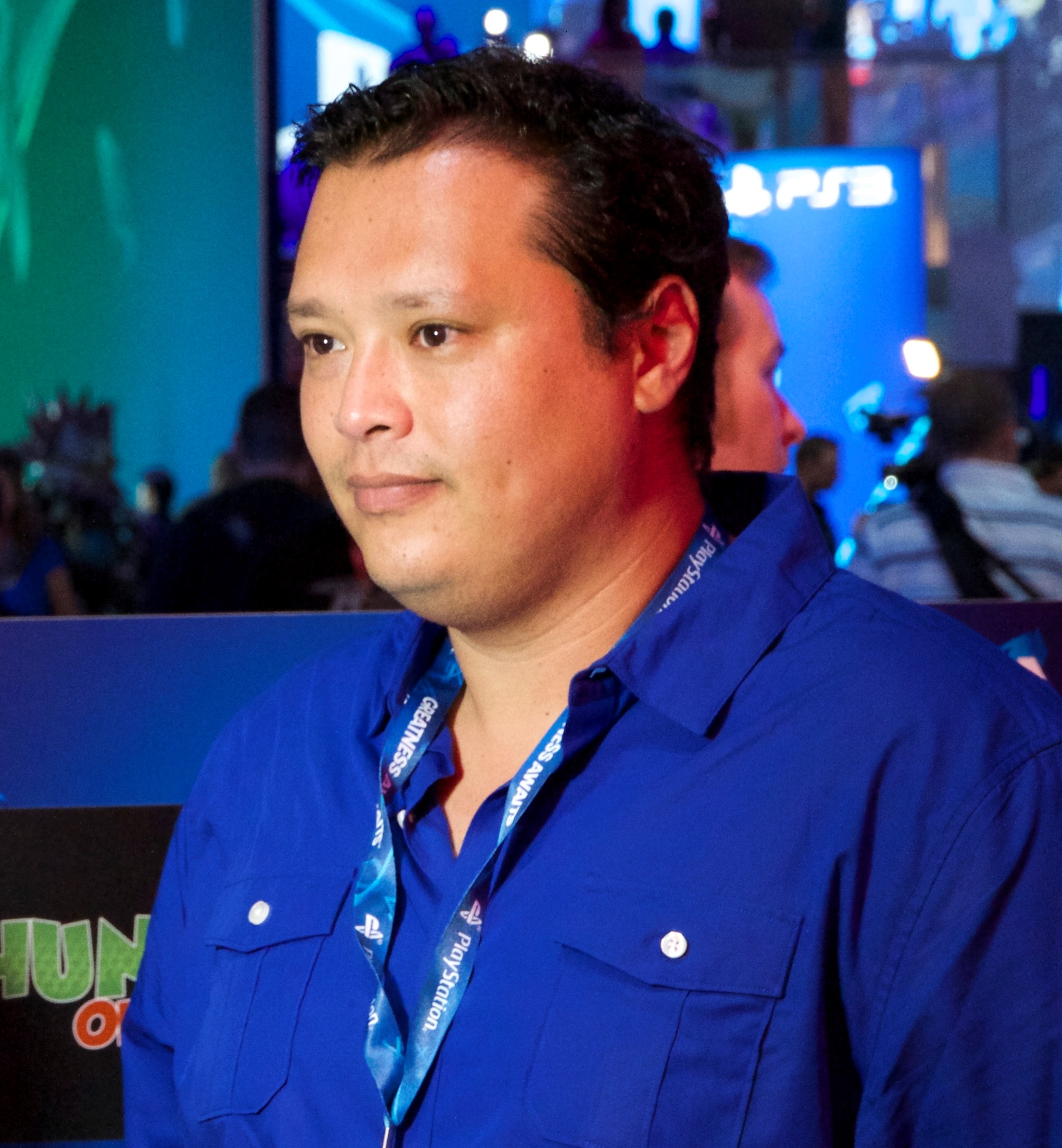 Andrew Dayton wearing a blue shirt and PlayStation lanyard at a games event