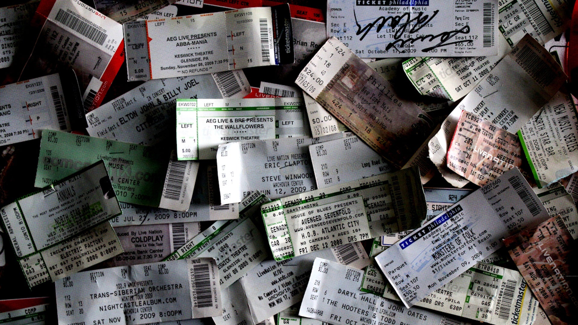 A collection of paper concert ticket stubs from different performers and venues.
