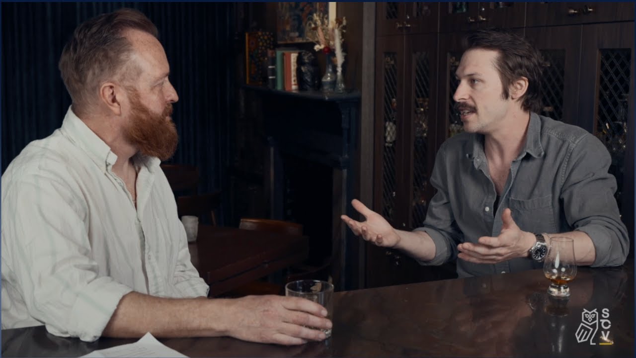 Hank Thomas, left, interviews Andrew Morris, right, across a table