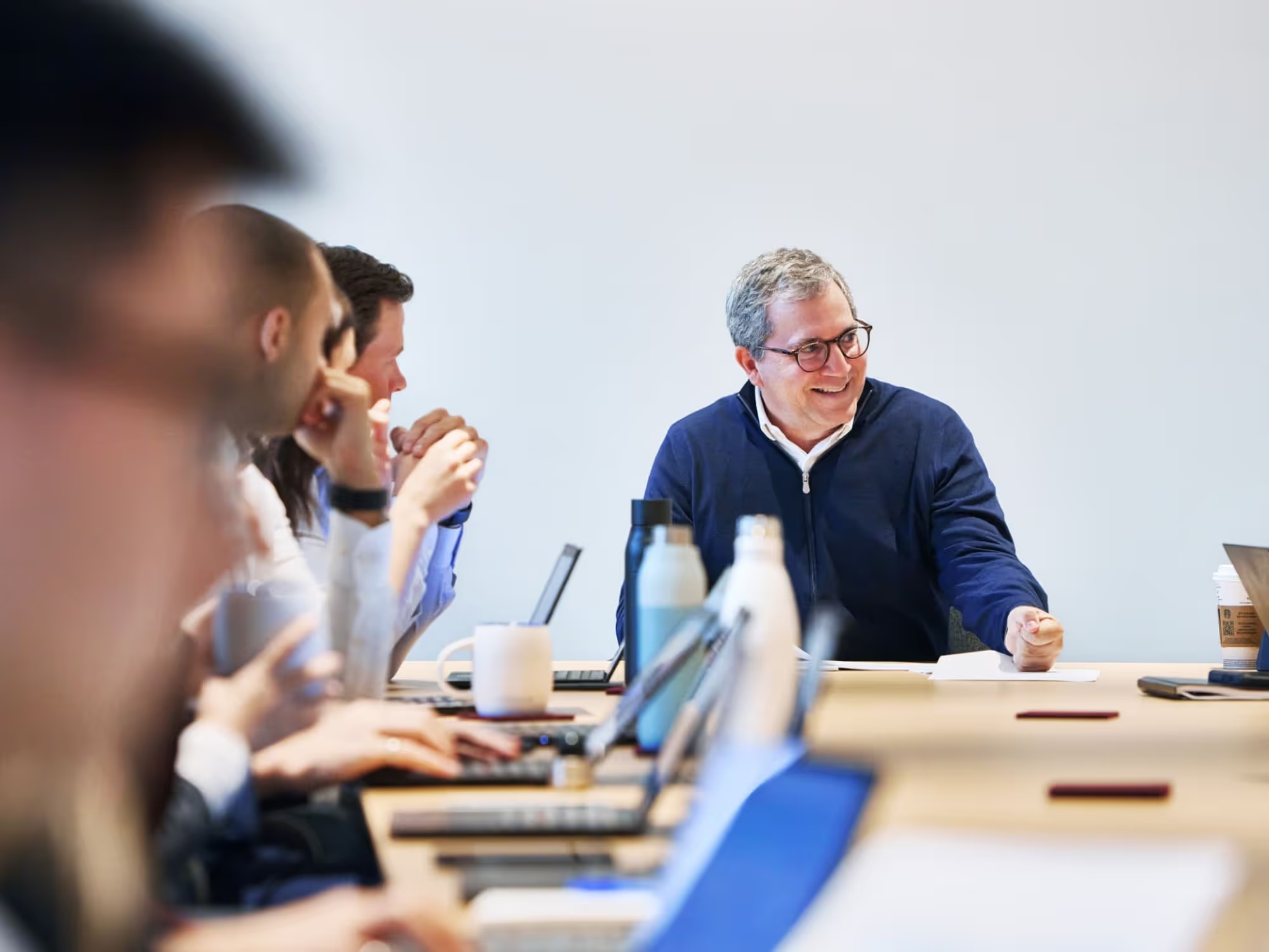Andrew Sheiner smiling during a meeting with colleagues around a conference table