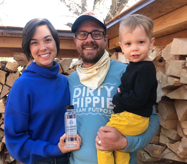 Abi and Andrew Vrbas with a bottle of Pacha hand sanitizer outside in Hastings