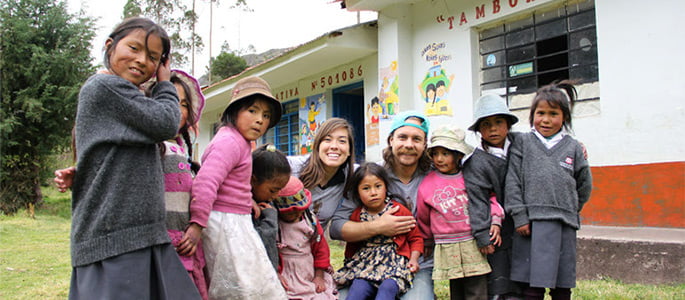 Andrew and Abi Vrbas with children outside a school in Peru in 2013