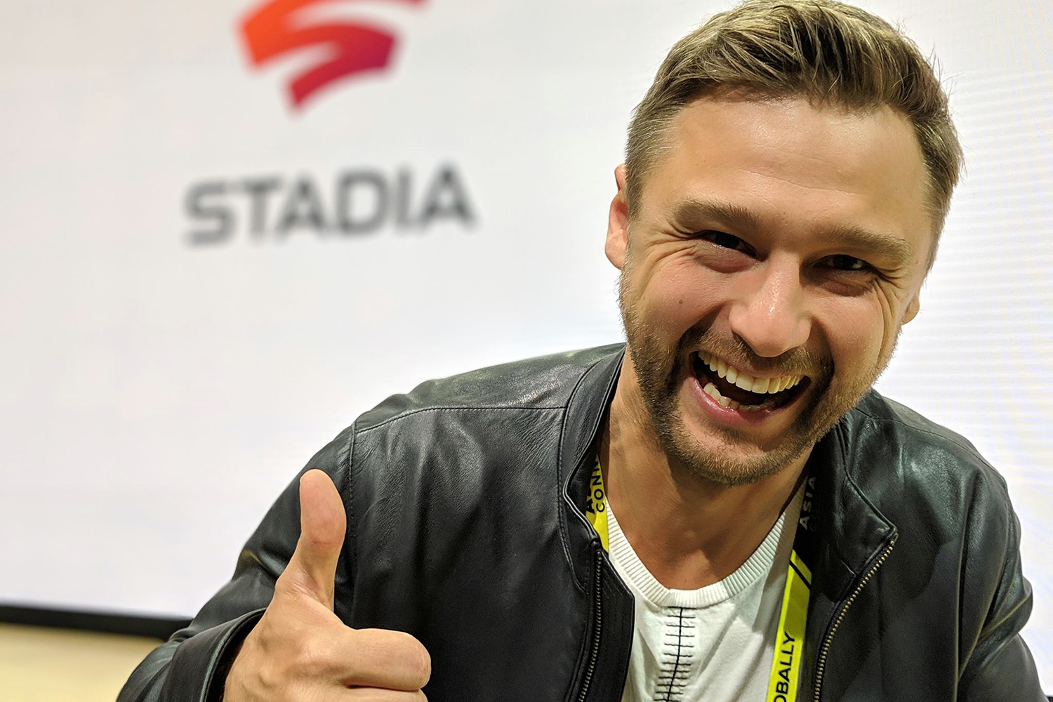 Andrey Doronichev smiling and giving a thumbs-up in front of a Stadia display