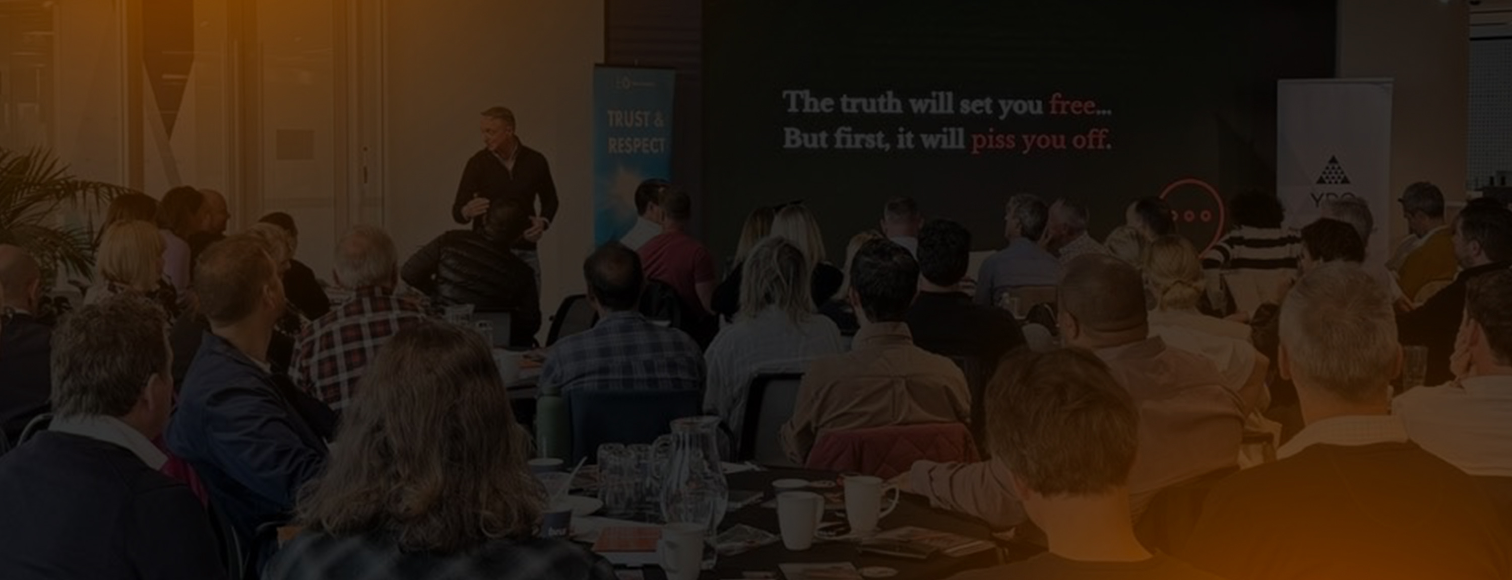 Andy Bailey speaking onstage to an audience