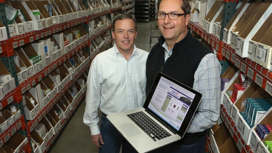 Andy Bane and Kurt Green standing in a Vetsource pharmacy aisle with a laptop