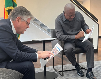 Andy Inglis and Ghana’s President John Dramani Mahama seated and examining printed documents