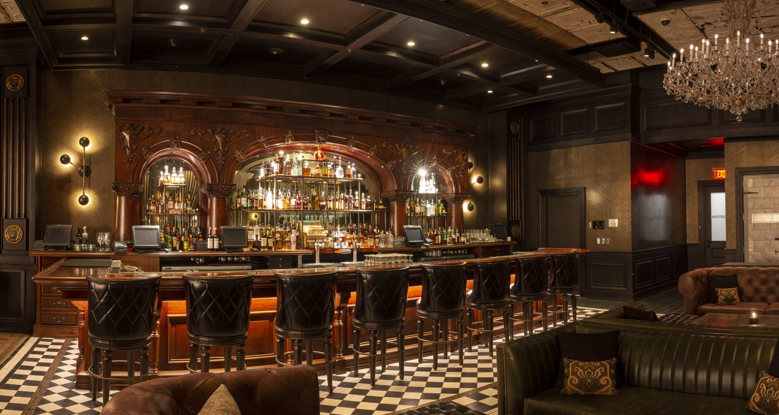 The Barbershop lounge, with its long wooden bar, chandeliers and upholstered seating