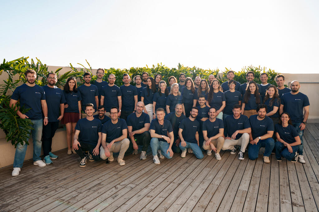 Anecdotes team gathered on a rooftop in company shirts
