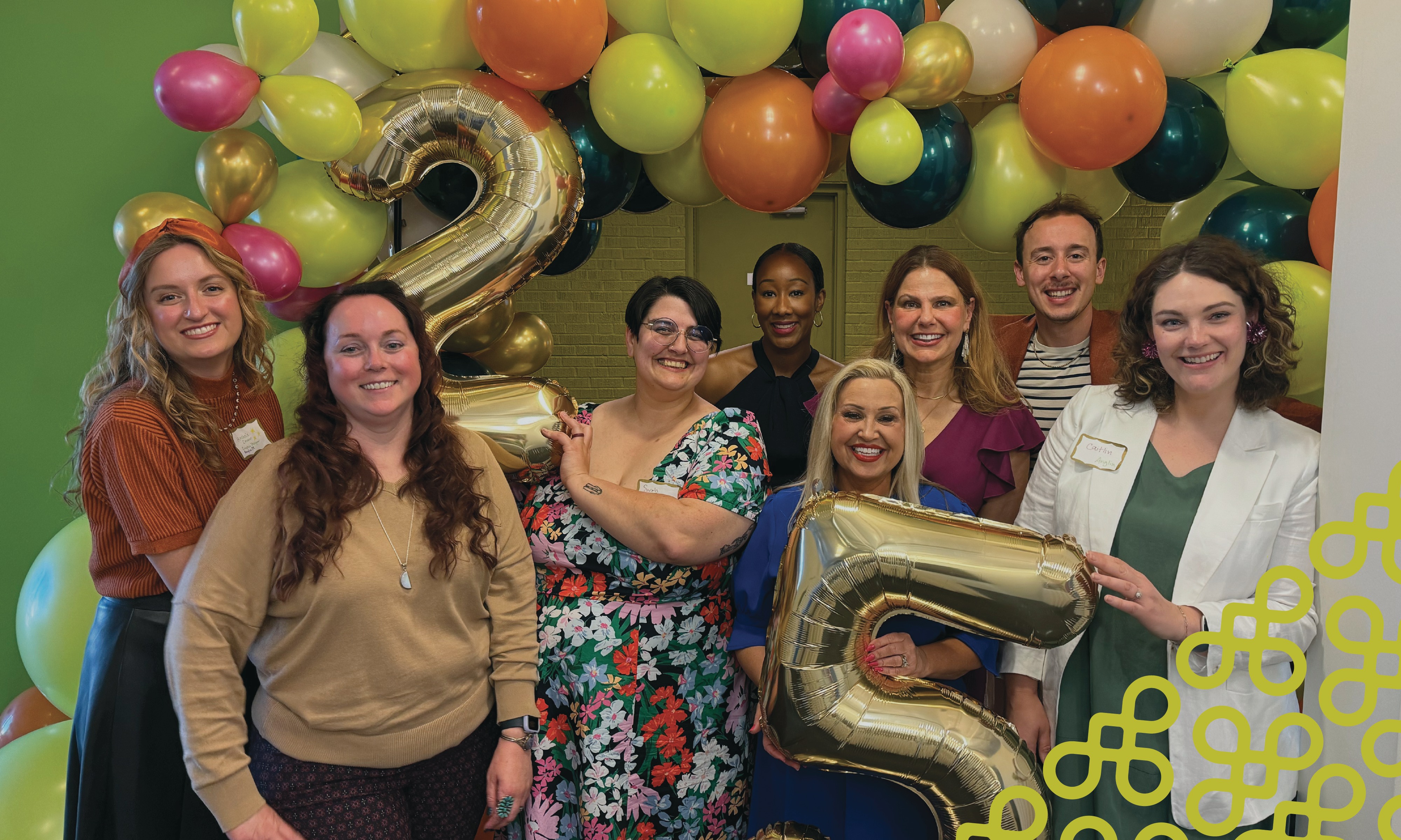The Anglin team gathered beneath colorful balloons at the firm's 25th-anniversary celebration