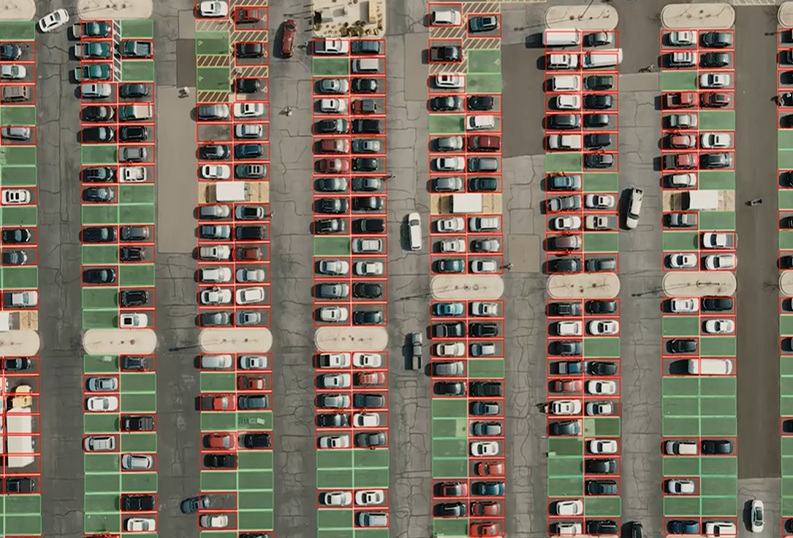 Aerial parking-lot image with red annotation boxes surrounding vehicles