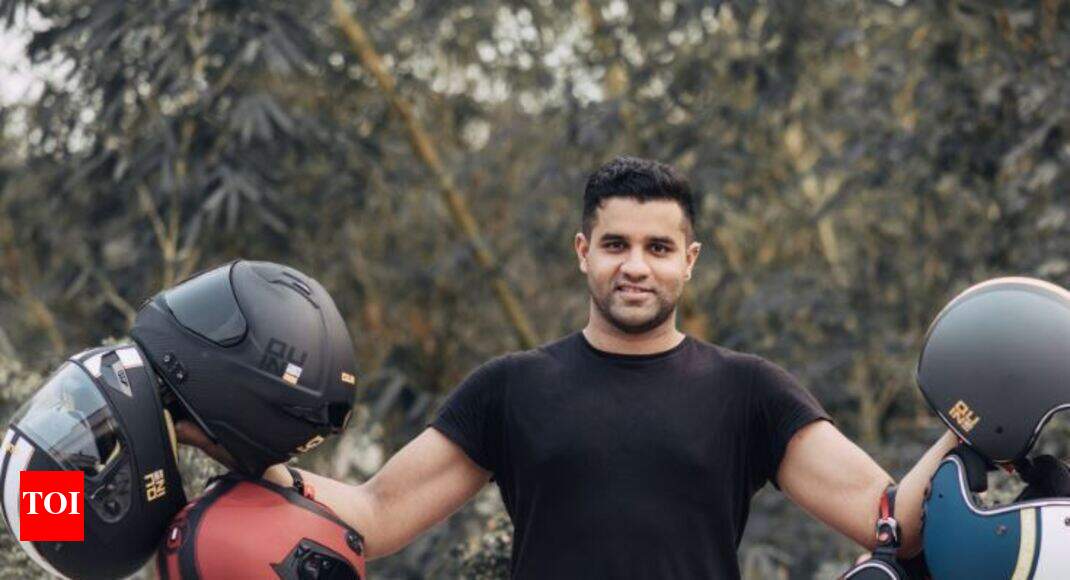 Anirudha Surabhi standing outdoors and holding four Quin motorcycle helmets