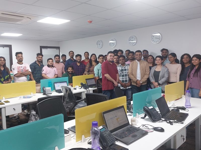 Ankit Shah with the InterSources team in their Noida office, with desks and four wall clocks