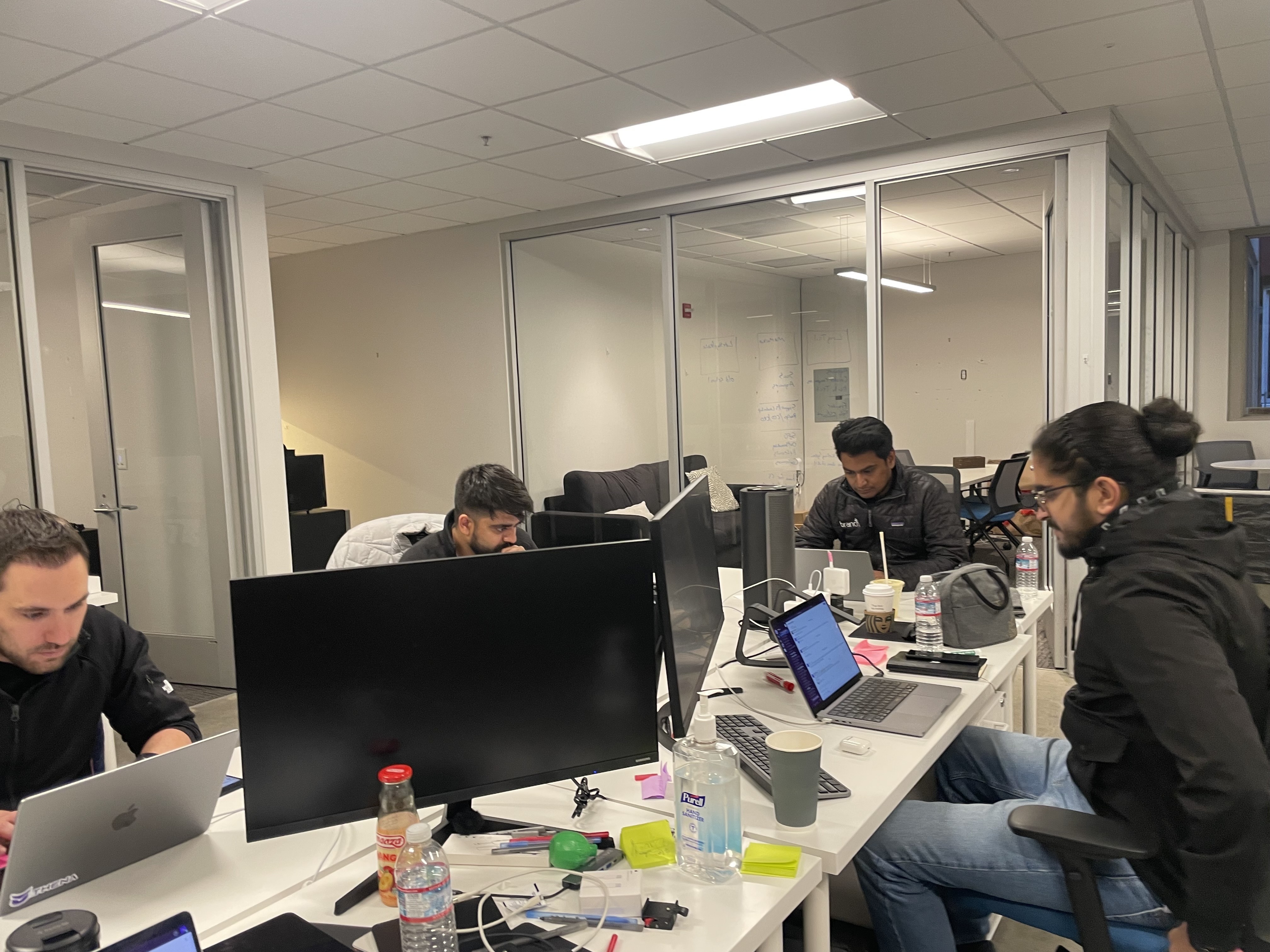 Thena’s early team working together at a shared table in its Palo Alto office in 2023