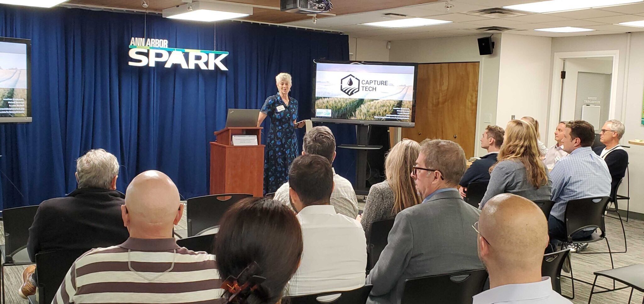 A founder presents a business pitch to an audience at Ann Arbor SPARK