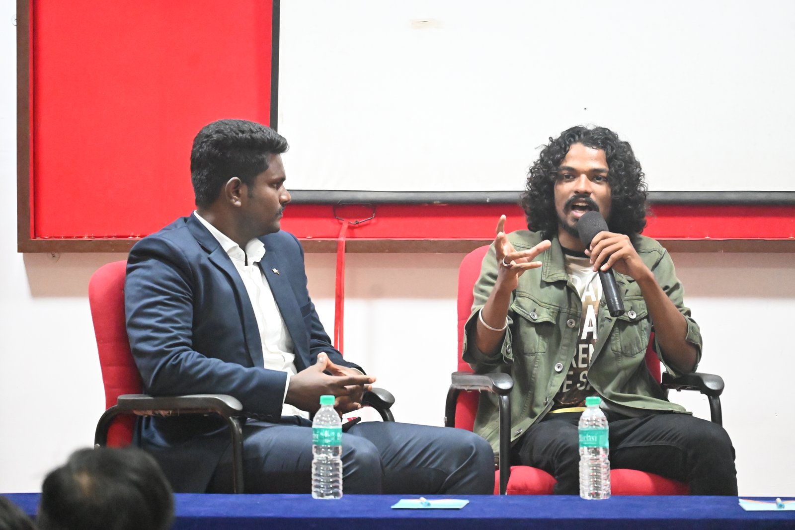 Two participants in a seated discussion pictured in AIIRF’s event gallery