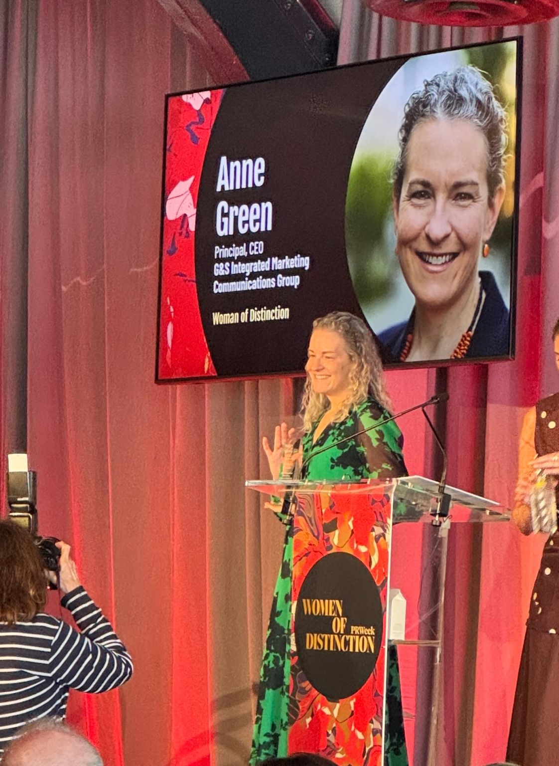 Anne Green accepting a PRWeek Women of Distinction award at a lectern