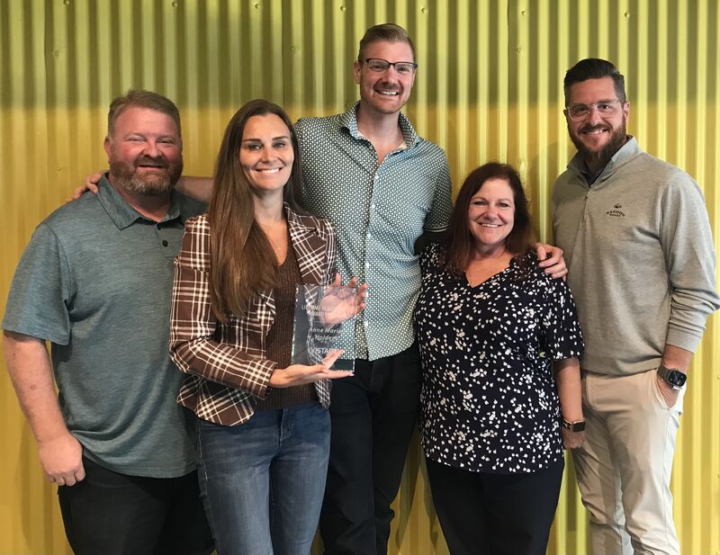 Anne Marie Holder, second from left, holding her Vistage recognition alongside four fellow attendees