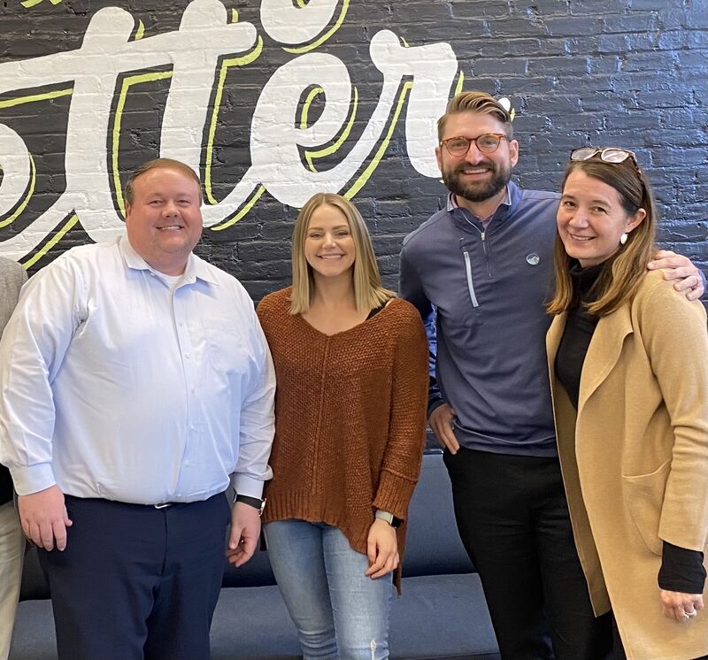 Annie Smith, at right, standing with three Ocozzio colleagues in front of a painted office wall