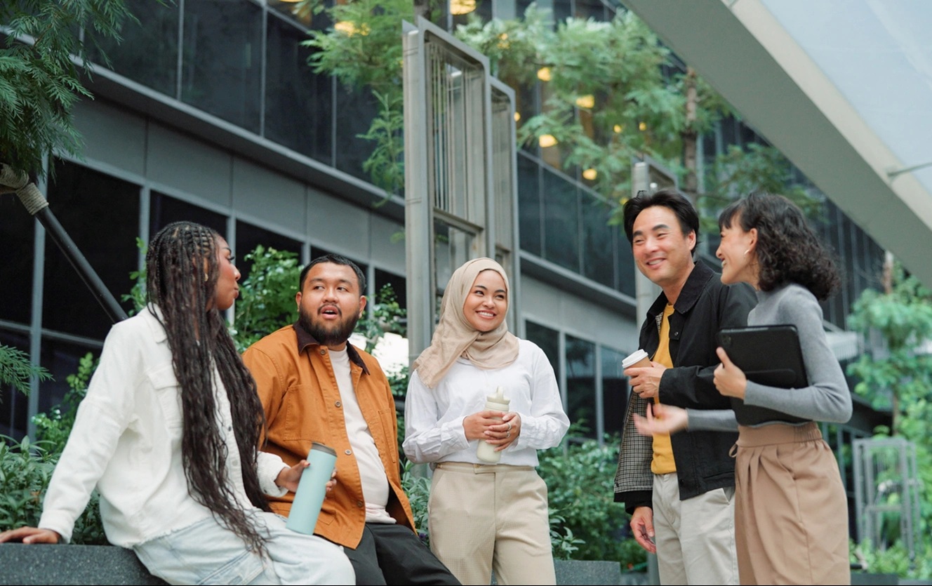 Five people talking in a landscaped courtyard in Ant International’s corporate diversity image