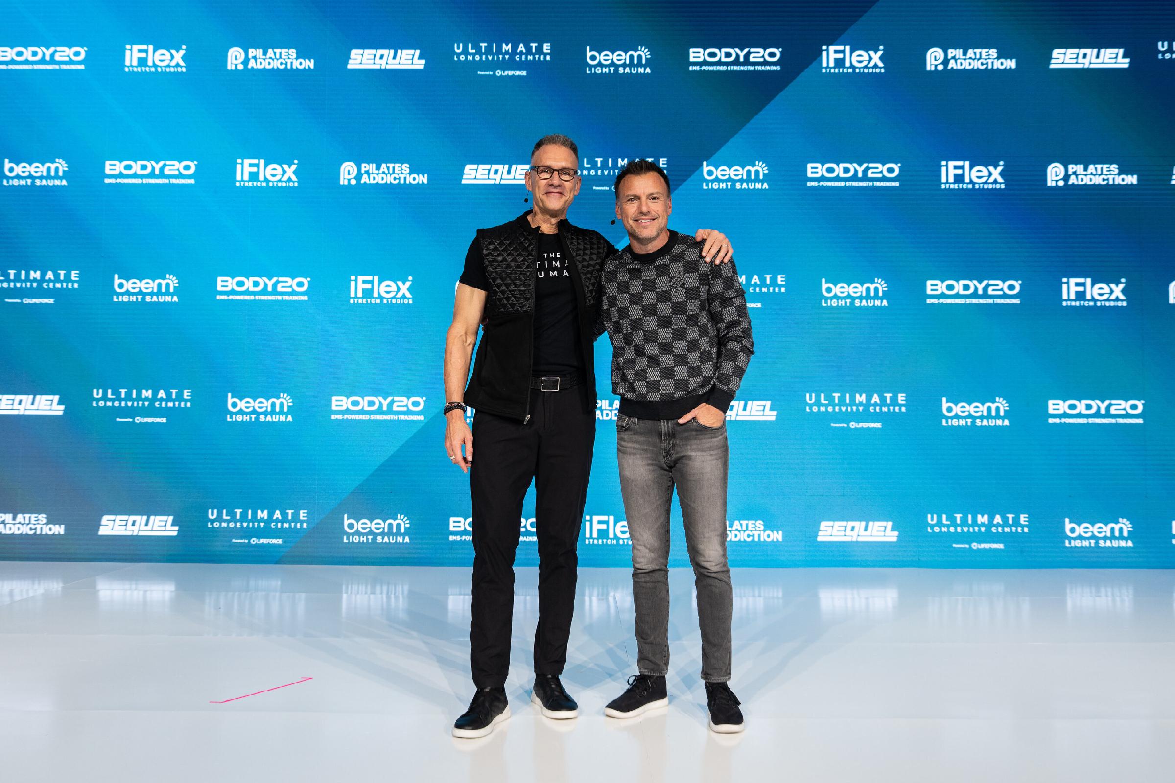 Anthony Geisler, right, with Gary Brecka in front of a Sequel Brands event backdrop