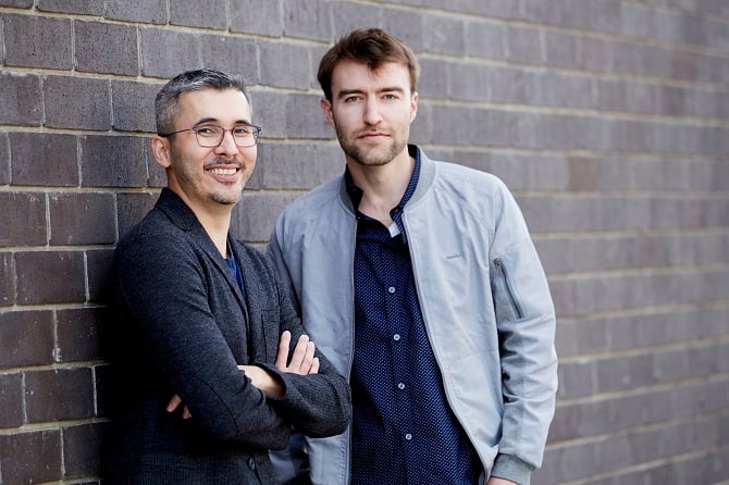 Anthony Leung and Aidan Karabaich standing together against a brick wall