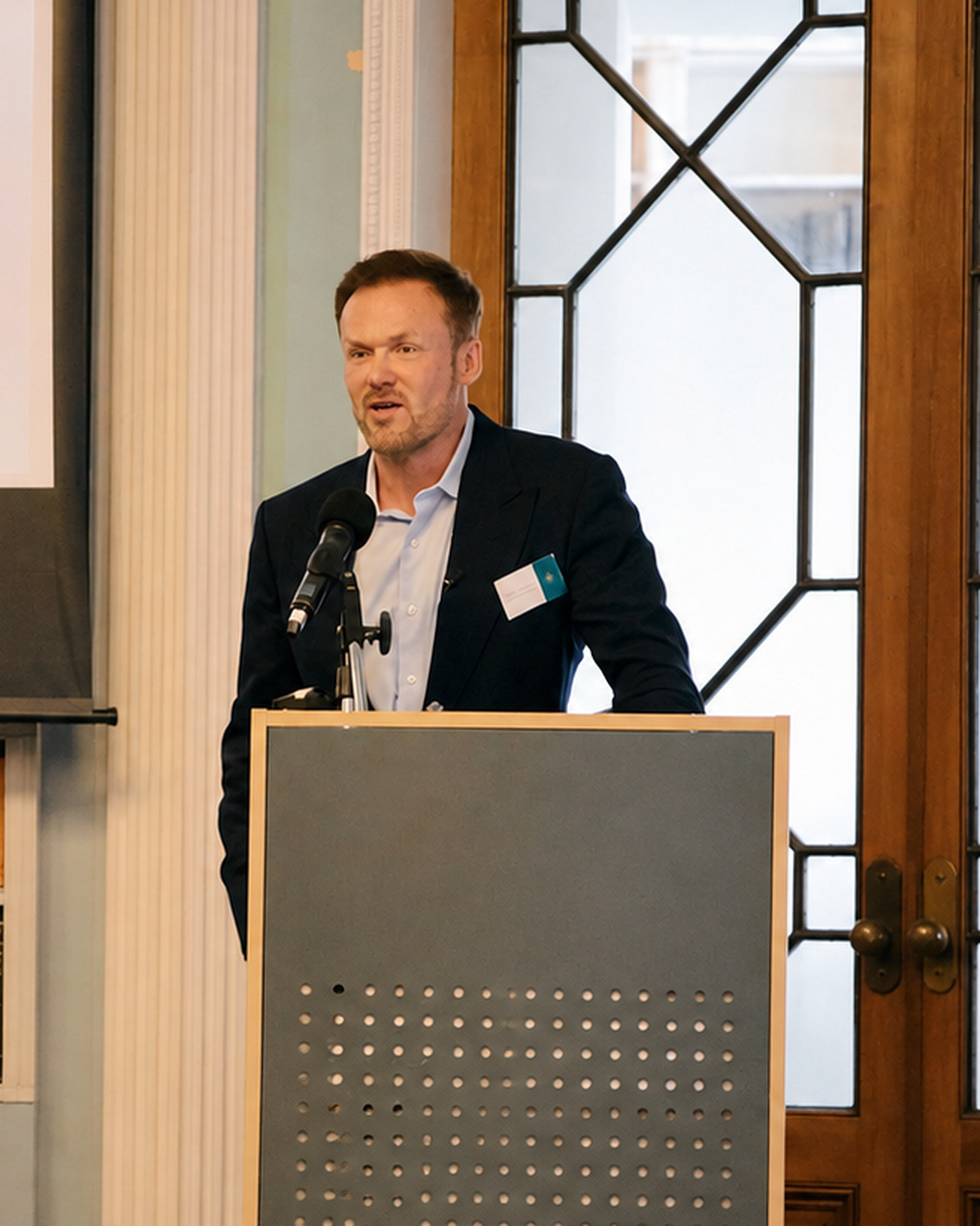 Anthony Venus speaking behind a lectern at Luminous’s Emergence event