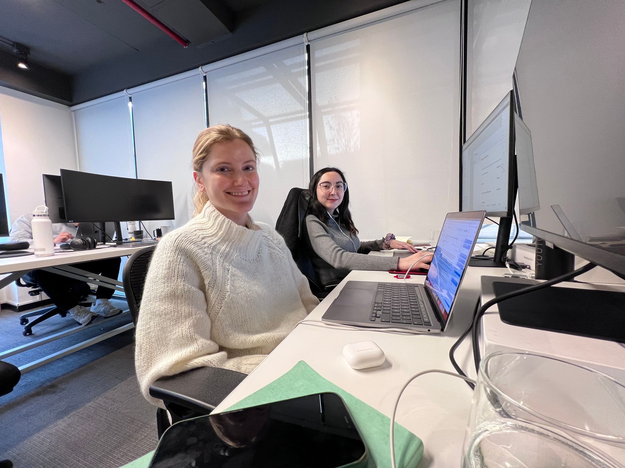 Antonia San Martín with a colleague at their desks in the Plutto office