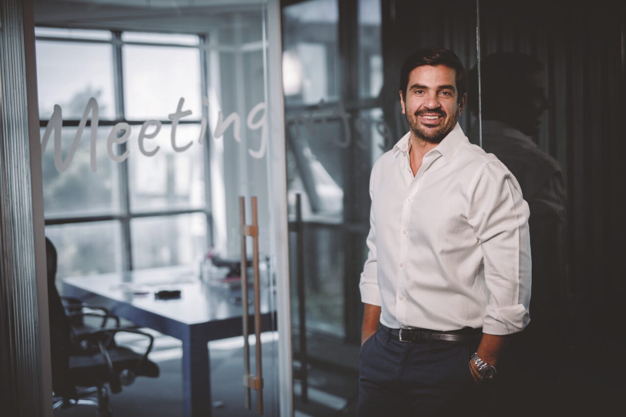 Antonis Markopoulos standing in a glass-walled Prosperty office