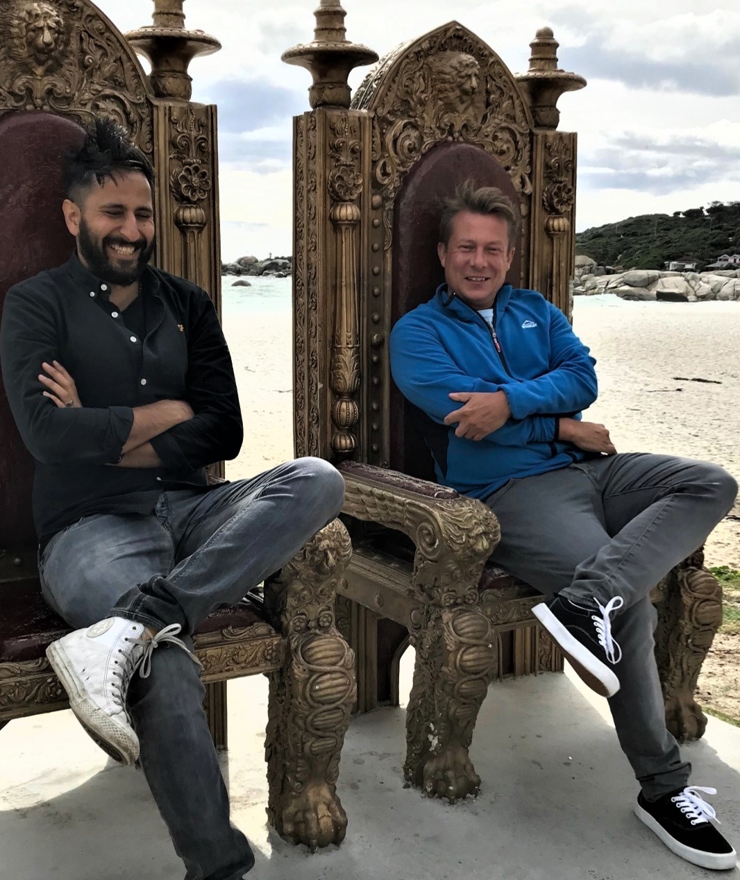 Anurag Bhalla, left, and Niclas Thelander seated in ornate chairs on a beach