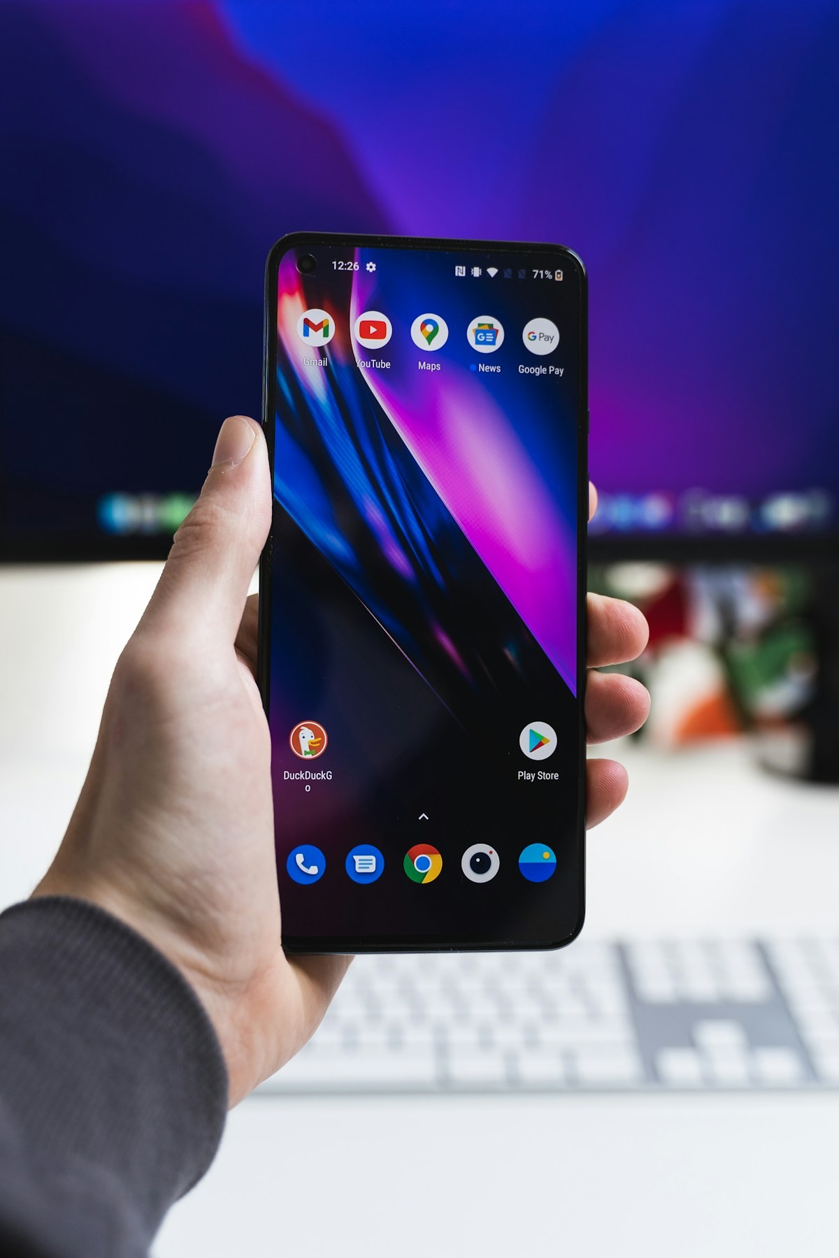 Android phone with Google apps and Play Store icon in a workspace