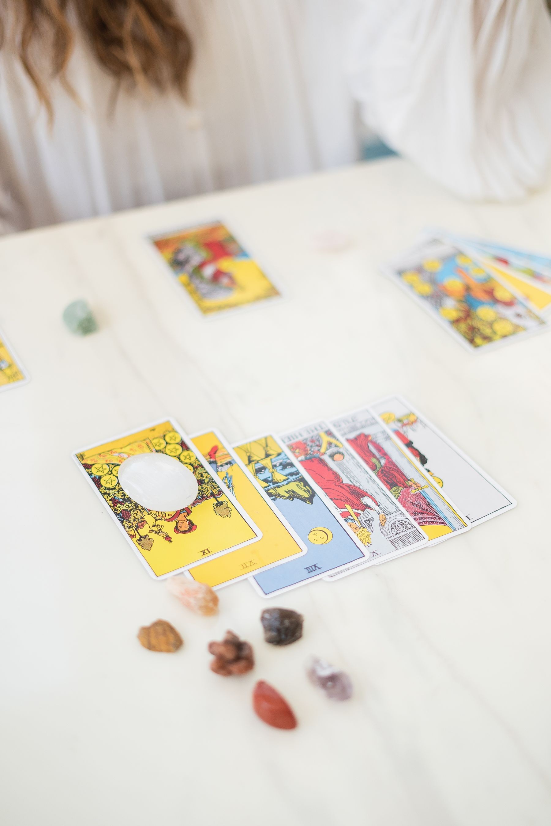 Tarot cards and crystals arranged on a table for a reading.