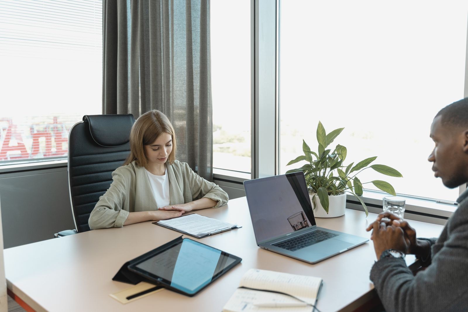 A candidate and interviewer review documents across an office desk