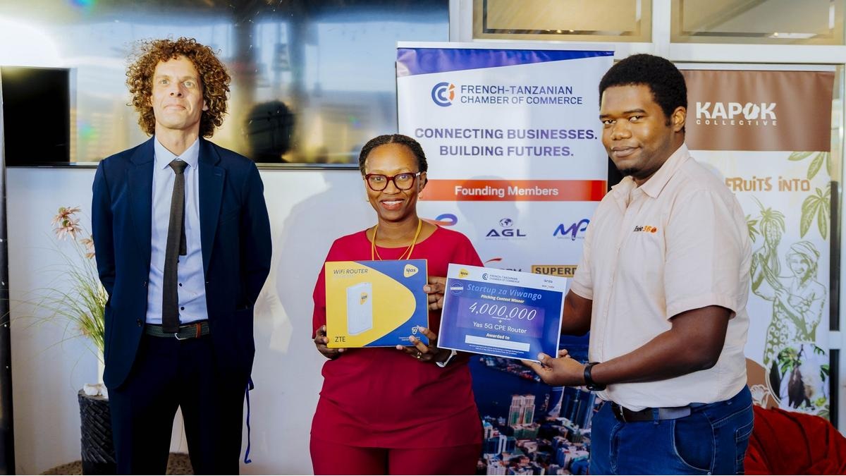 Participants holding award boards at the Startup za Viwango pitching contest