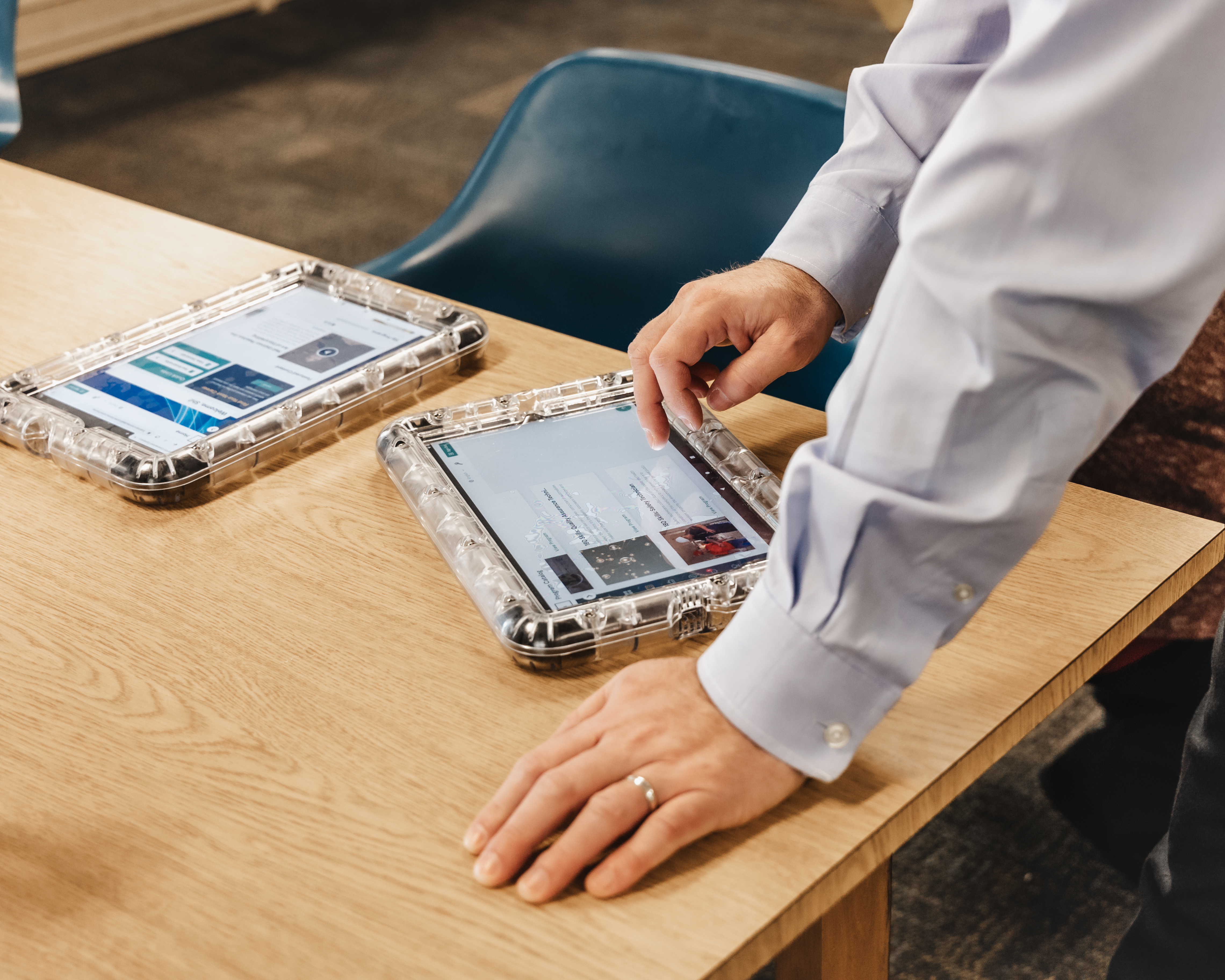 Two secure Orijin tablets in transparent protective cases on a wooden table