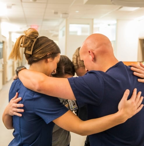 Piedmont Healthcare colleagues in a group embrace, photographed for Appcast’s employer branding work