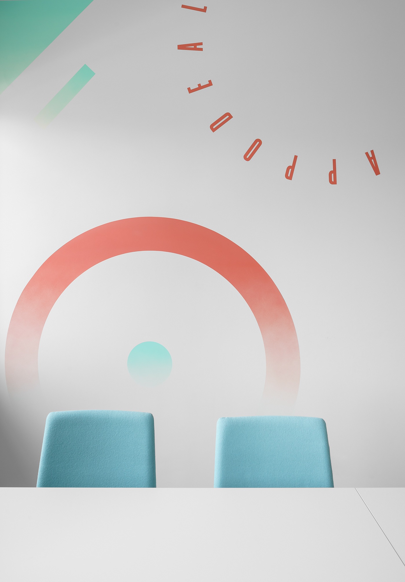 Two turquoise chairs below circular red and mint graphics in Appodeal’s former Minsk office