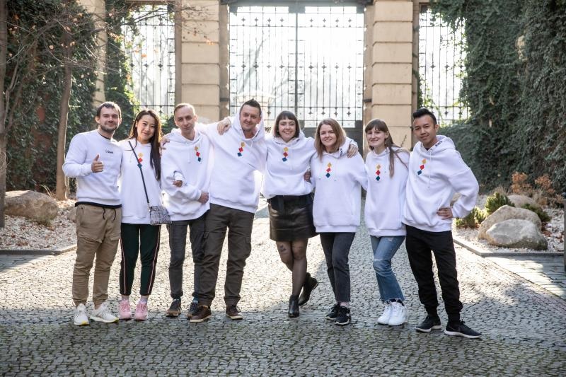 Eight Appodeal colleagues wearing matching white hoodies in a courtyard