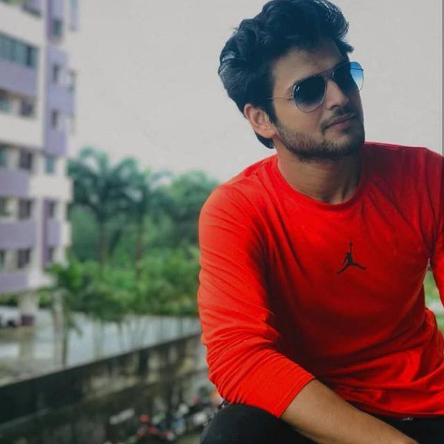 Appul Vats outdoors in a red shirt and sunglasses