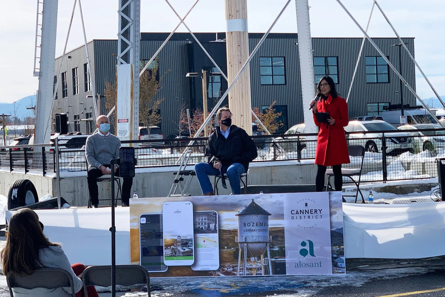 April LaMon speaks at the outdoor Cannery District app launch in Bozeman as Barry Brown and Montana Governor Steve Bullock sit nearby