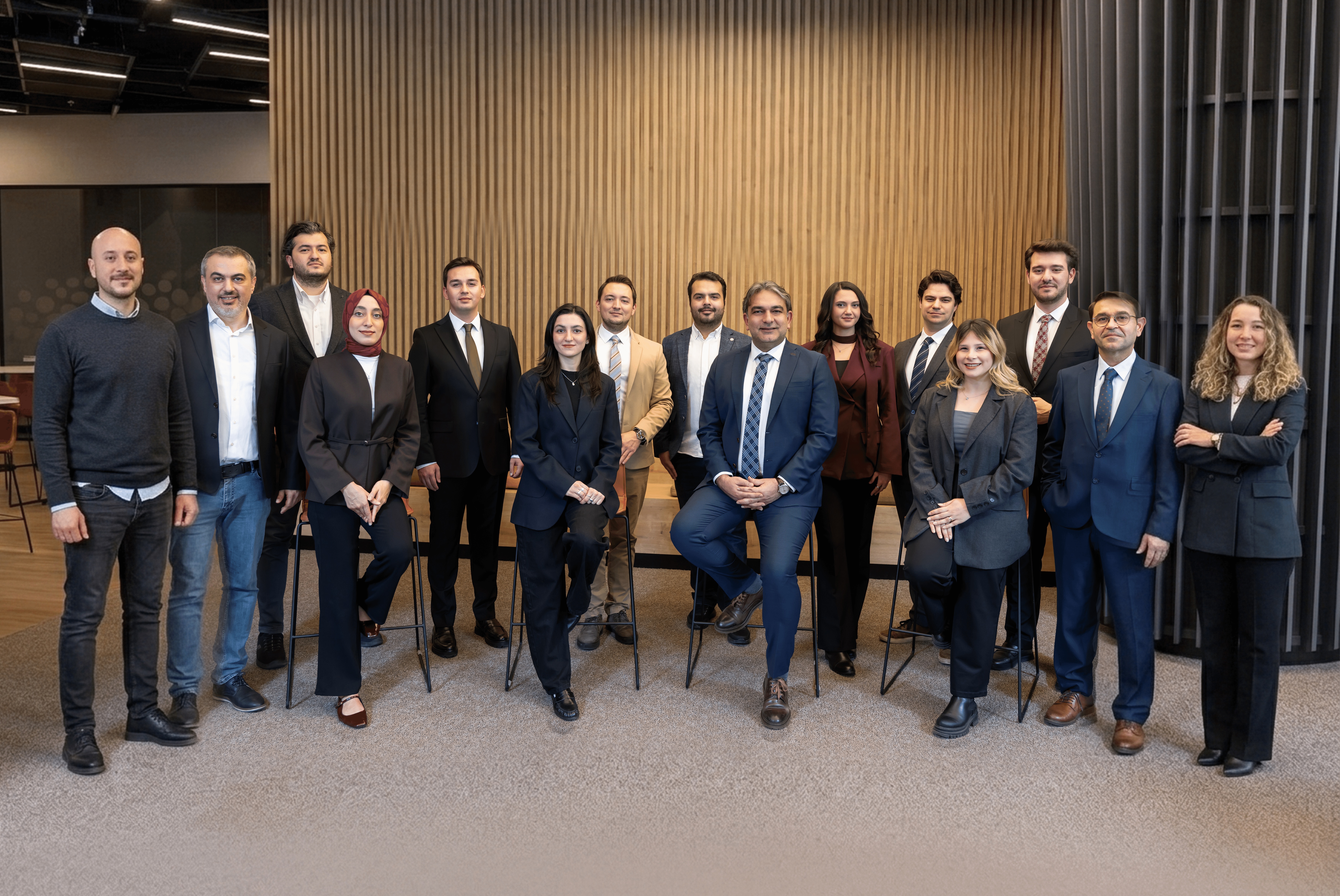 The APY Ventures team pictured together in a wood-panelled workspace