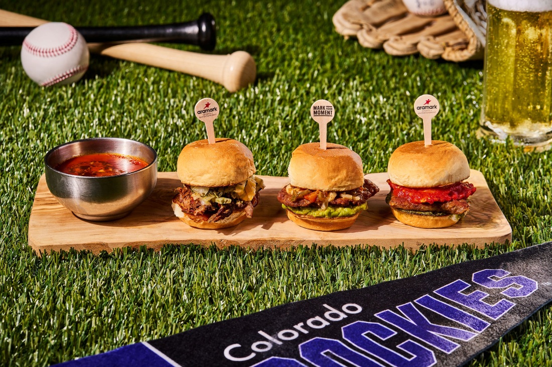 Three Aramark sliders on a wooden board with Colorado Rockies baseball props
