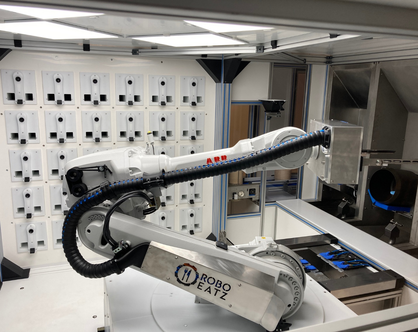 An ABB robotic arm inside a RoboEatz automated kitchen with ingredient storage bins