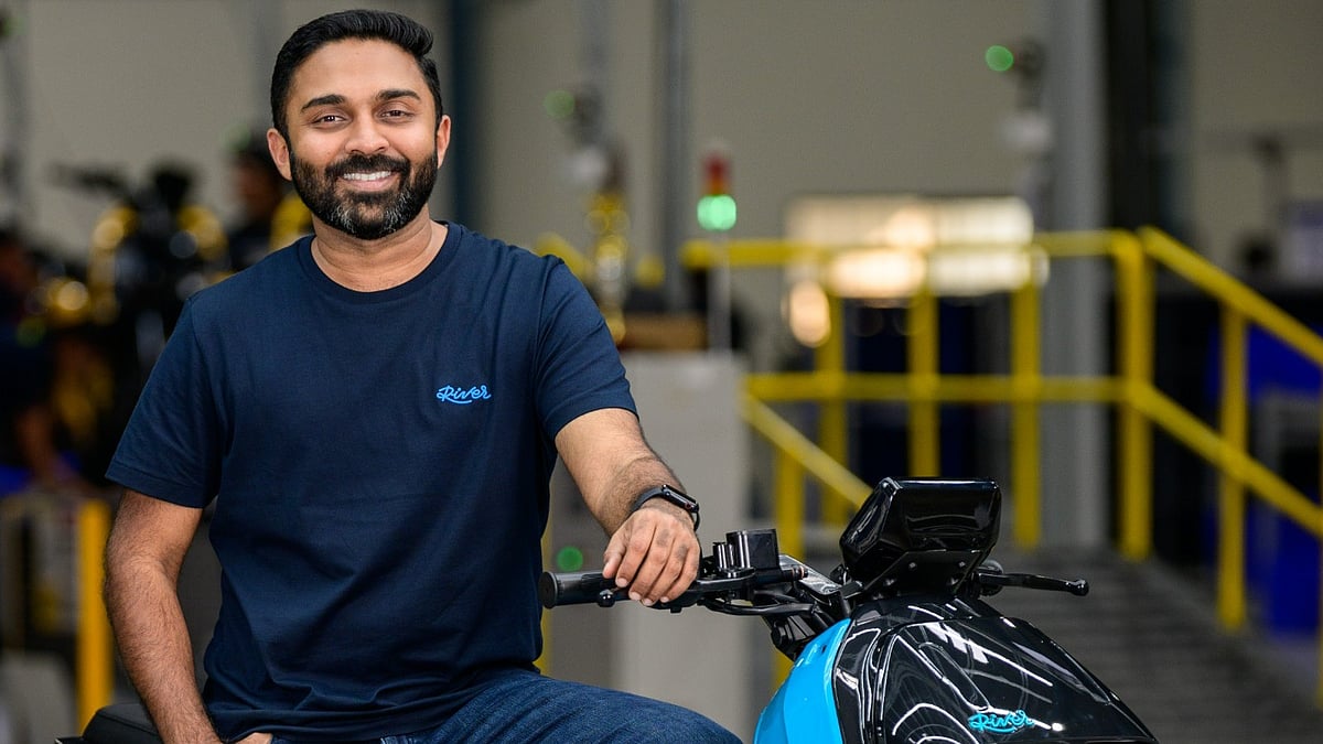 Aravind Mani seated on a blue River Indie inside a manufacturing facility