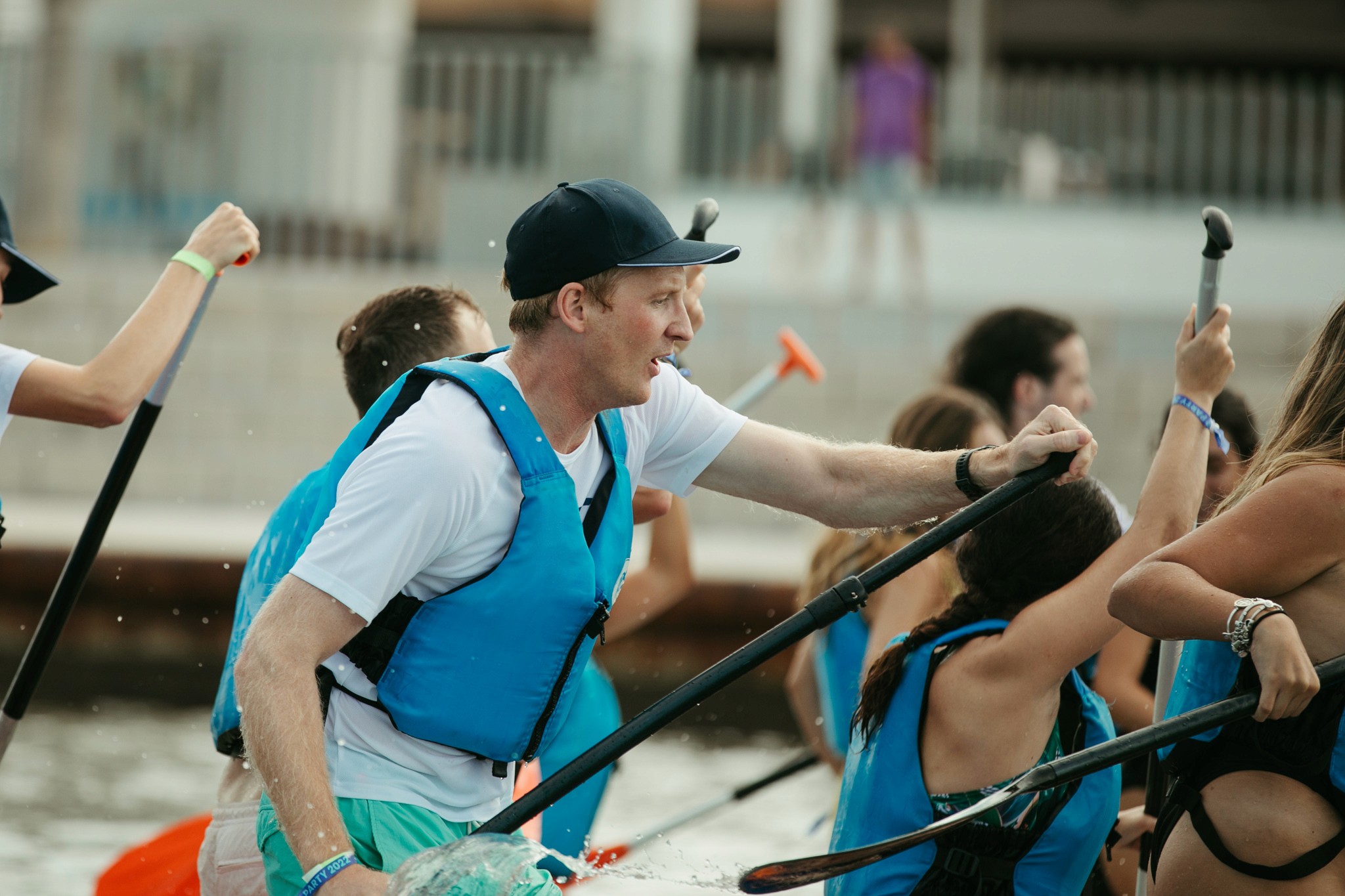 Arbolus team members wearing life jackets and paddling together at an outdoor event