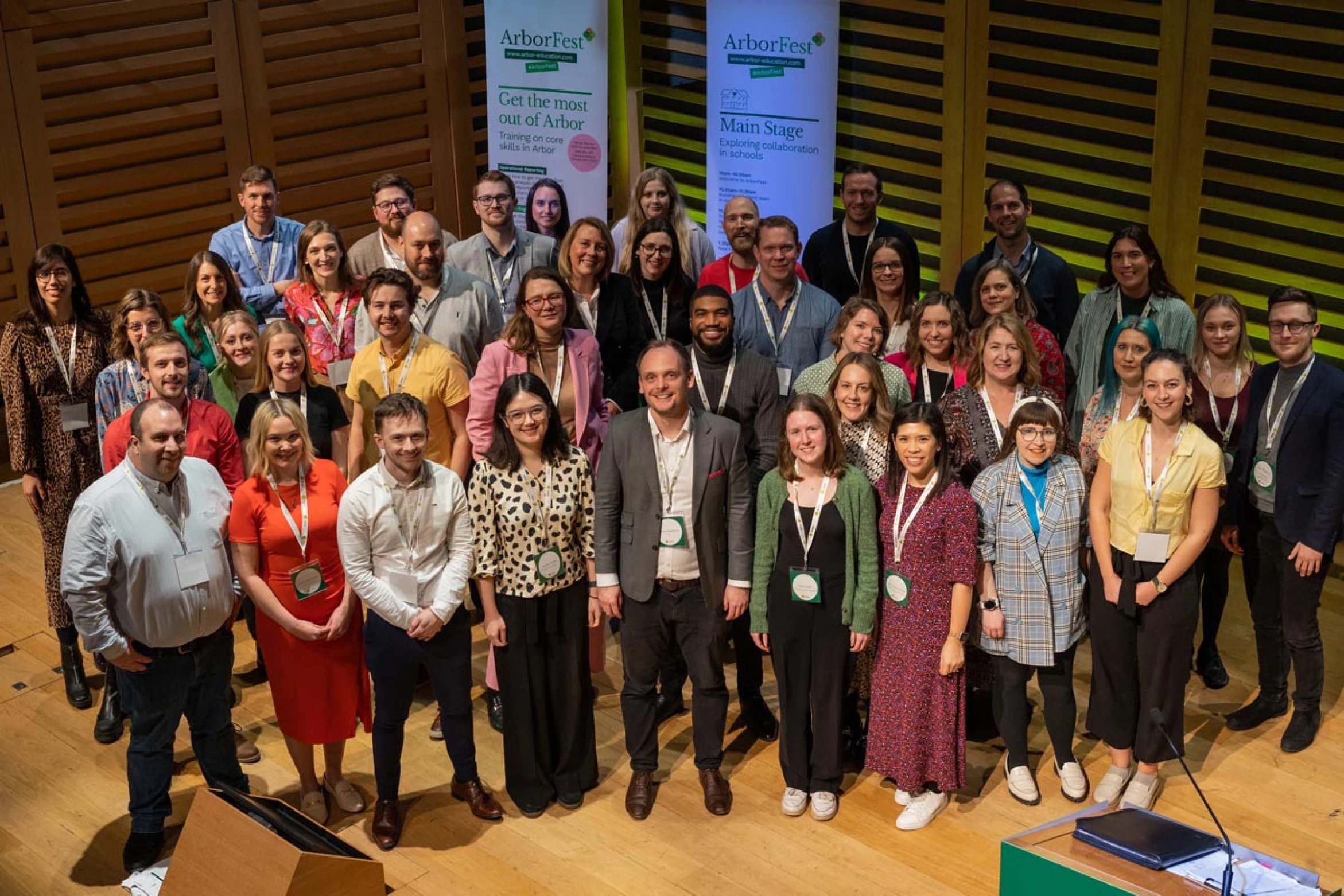 Group photograph at ArborFest, with conference banners behind the participants