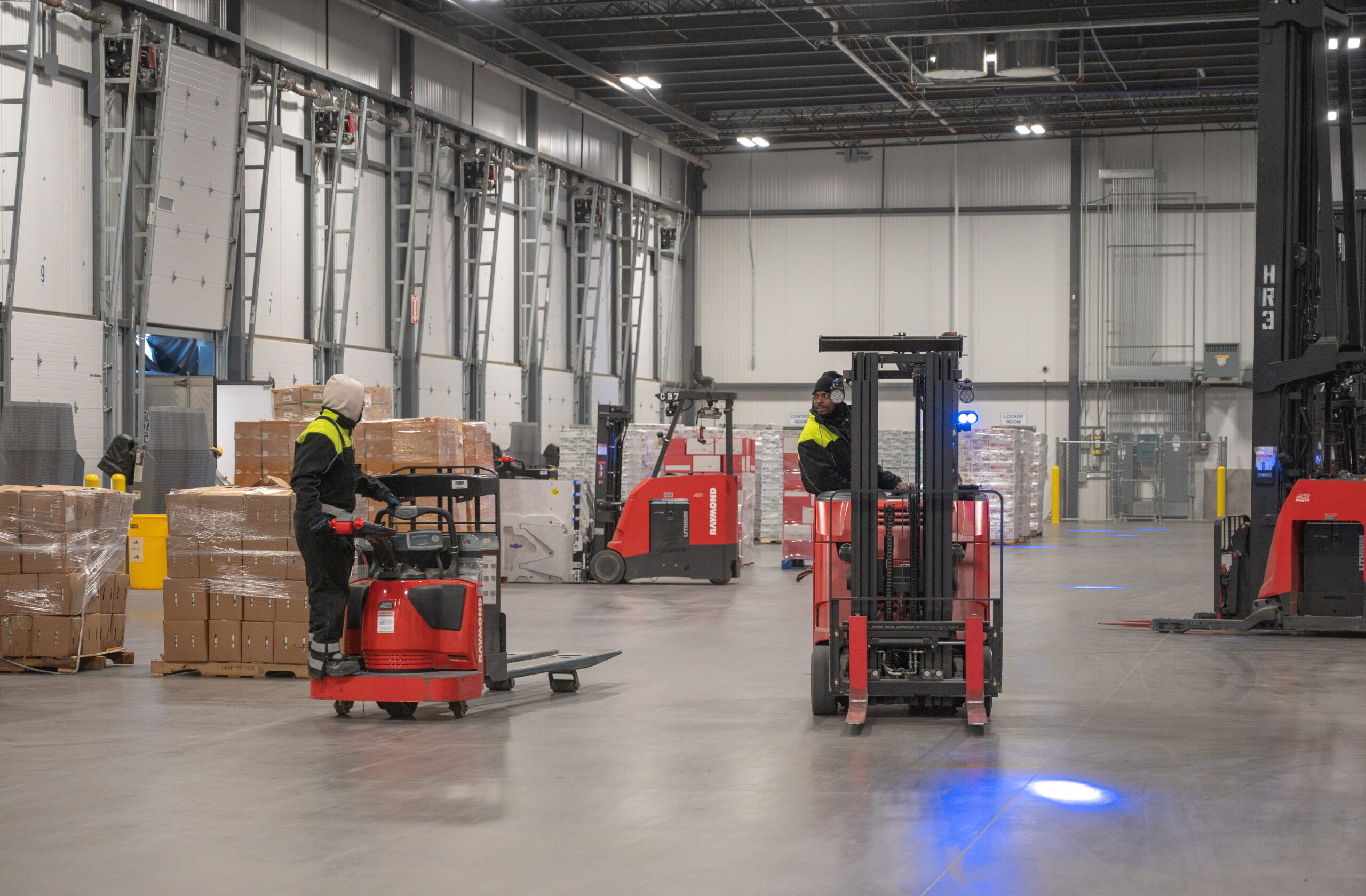 Two workers operating forklifts inside Arcadia’s Atlanta warehouse