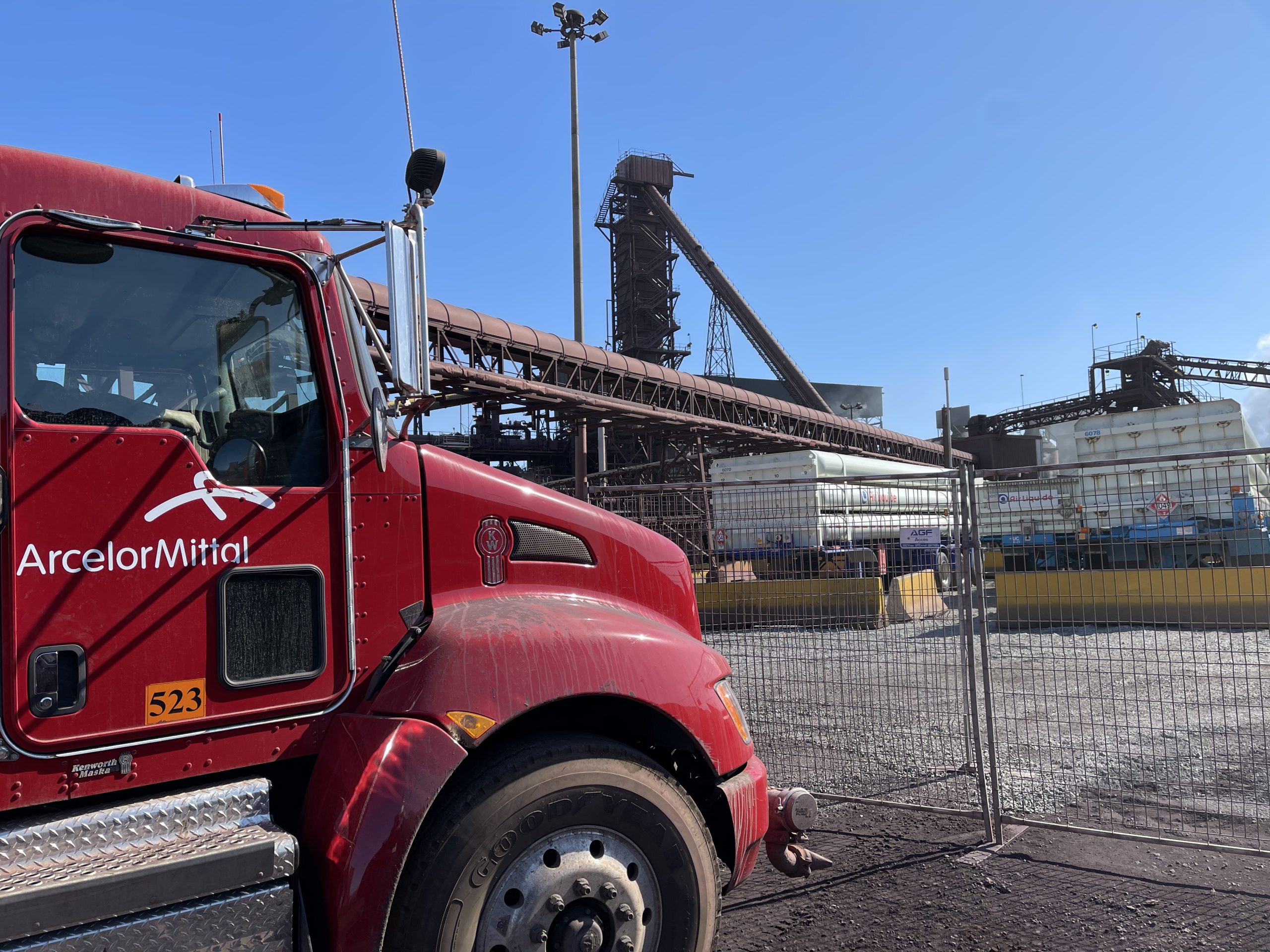 A red ArcelorMittal truck in front of the Contrecoeur industrial complex