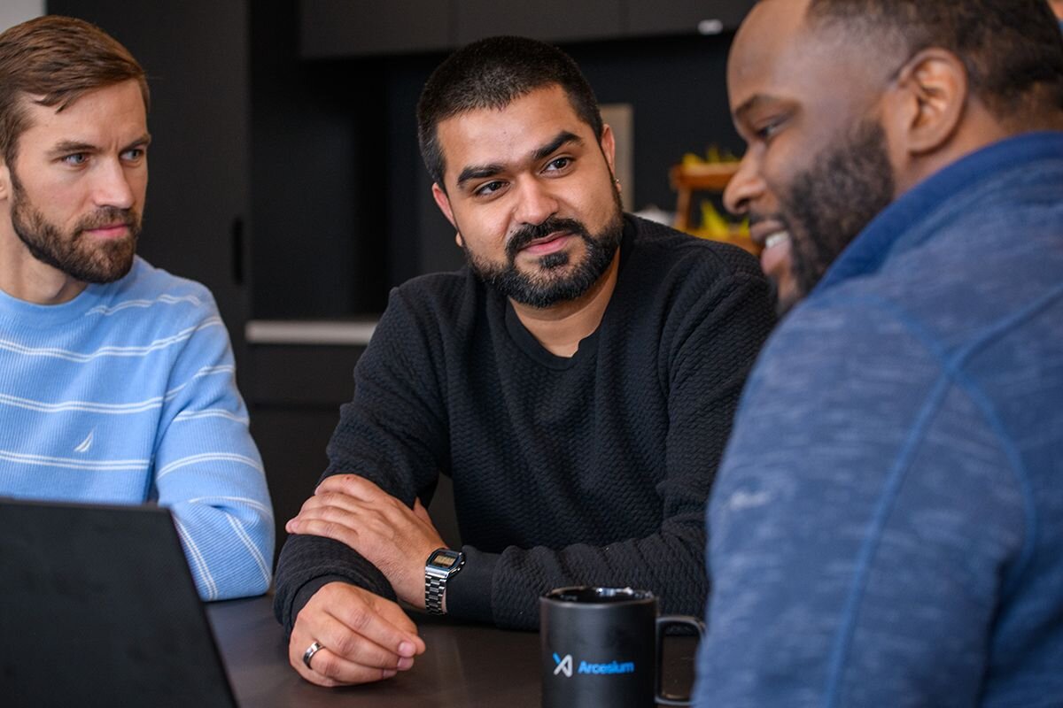 Arcesium colleagues in conversation at an office