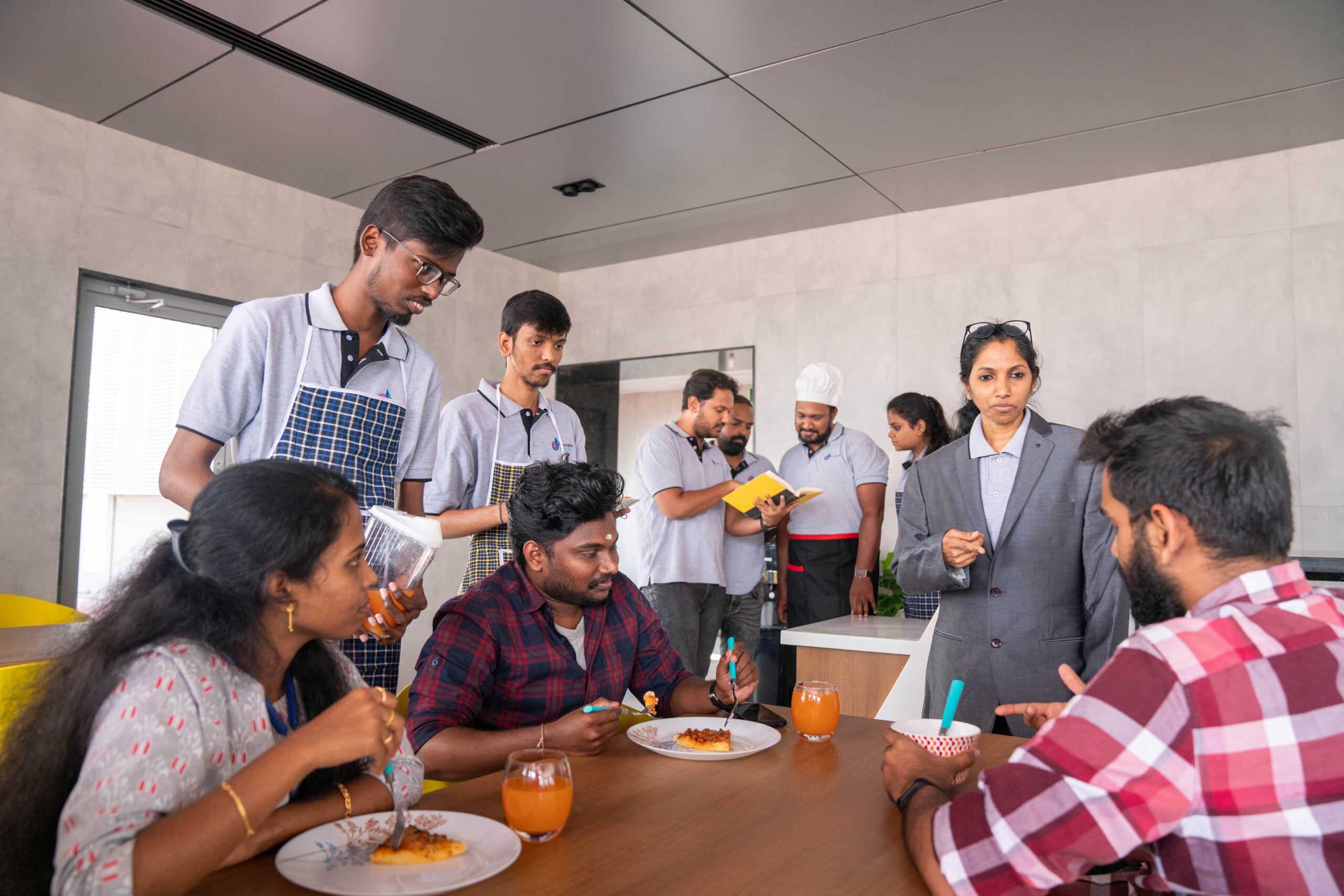 Archimedis team members in a shared kitchen setting, some preparing food and others seated at a table