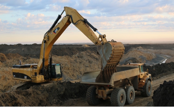 Excavator loading aggregate material into a haul truck